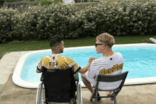 a man in a wheelchair sits next to a man in a neyney jersey