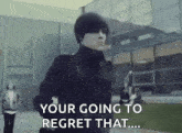 a man in a black jacket is running in front of a building and says `` your going to regret that '' .