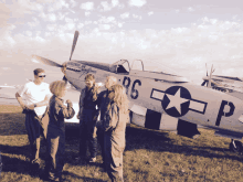 a group of people standing in front of a plane with the letters rg and p on it