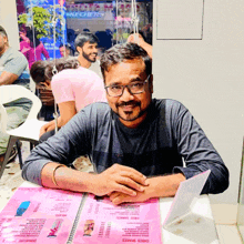 a man sits at a table with a menu in front of him that says choco shakes