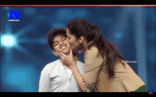 a woman kisses a boy on the cheek on a television screen that says malemala tv