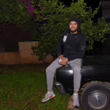 a man is sitting on the back of a black truck with a tag that says ' a ' on it