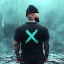 a man wearing a black t-shirt with an x on the back