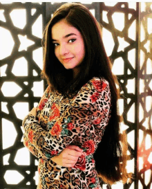 a girl with long hair wearing a leopard print top