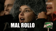 a woman wearing a fur hat says mal rollo while sitting in a crowd of people .