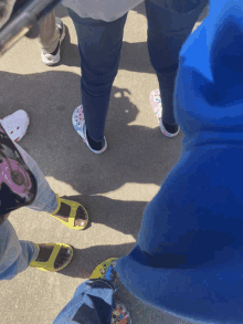 a group of people standing on a sidewalk wearing colorful shoes