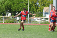 a rugby player wearing a red jersey with the word rugby on the front