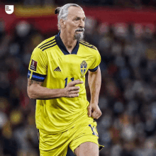 a soccer player wearing a yellow adidas jersey with the number 11 on it