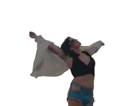 a woman in a black top and blue shorts is dancing