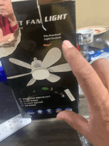 a person is holding a box of a fan light