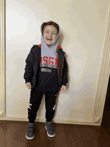 a young boy wearing a msgm hoodie and black pants