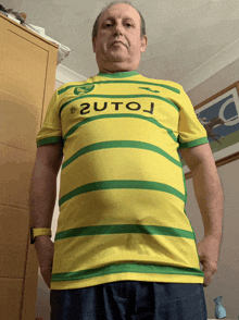 a man wearing a yellow and green striped shirt with the word 2utoj on the front