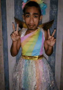 a man dressed as a unicorn is giving a peace sign .