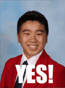 a young boy in a red jacket and tie is smiling with the word yes written below him