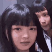 a close up of a girl 's face with a man behind her .