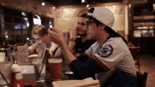 a group of young men are sitting at a table in front of a wall that says ' budweiser ' on it