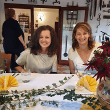 two women are sitting at a table in front of a sign that says nachtleben