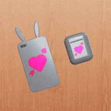 a phone case with bunny ears has a pink heart on the back