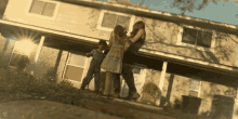 a group of people are standing in front of a house that has the number 10 on the front door