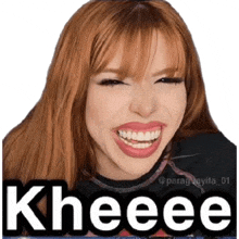 a woman with red hair is smiling and making a funny face with the words kheeee .