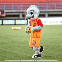 a mascot for borneofc.id is holding a soccer ball on the field