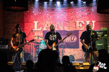 a band performs on stage in front of a banner that says lanceu