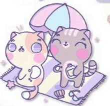 a couple of cats sitting on a blanket under an umbrella .