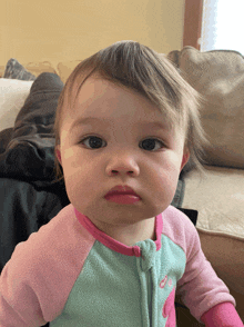 a baby is wearing a pink and blue outfit with the letter c on the front