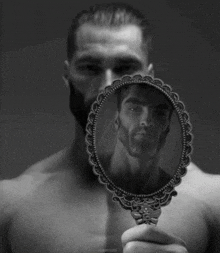 a shirtless man is looking at his reflection in a small mirror