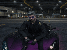 a man in a suit is sitting on the hood of a purple car