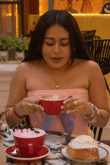 a woman sitting at a table with a cup of coffee and a piece of cake