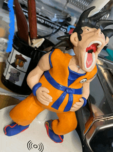 a figurine of a man with his mouth open is on a table next to a pencil holder