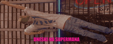 a man is laying on his back in front of a sign that says ' dneski na supermana '