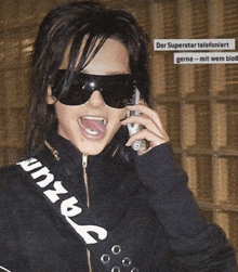 a woman wearing sunglasses and talking on a cell phone .