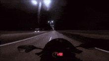 a person riding a motorcycle down a road at night