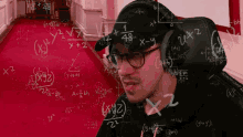 a man wearing glasses and a hat is surrounded by math equations including x + 2