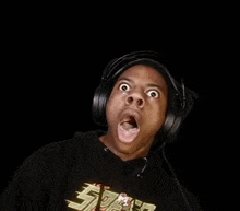 a man wearing headphones is making a funny face with his mouth open .