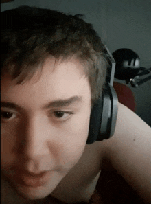 a young man wearing headphones without a shirt on