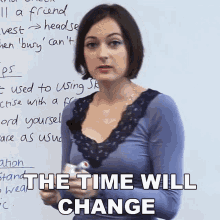 a woman stands in front of a white board with the words " the time will change " on the bottom