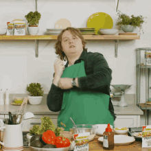 a man in a green apron is standing in a kitchen with a packet of ranch dressing on the counter