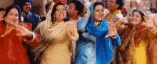 a group of women are dancing together in front of a crowd of people .