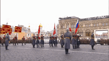 a group of soldiers marching in a parade holding flags with one that says " russian federation " on it