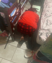 a girl in a red plaid skirt is crawling on the floor