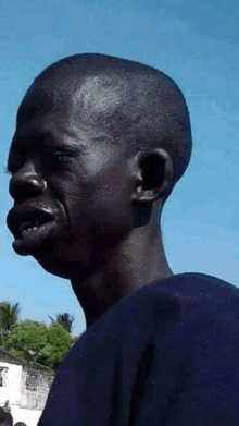 a close up of a man 's face with a blue sky in the background