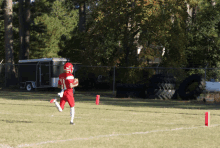 a football player in a red and white uniform runs on the field