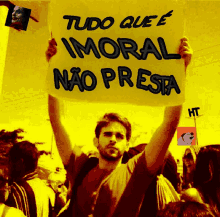 a man holding up a sign that says tudo que e immoral nao presta