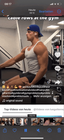 a phone screen shows a video of a man doing exercises in a gym