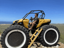 a man sits on a yellow can-am vehicle