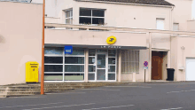 a la poste building with a yellow sign above the door