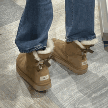 a person wearing a pair of ugg boots with a bow